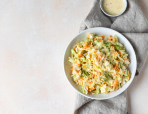 Bowl of creamy coleslaw with shredded cabbage and carrots in Paleo mayonnais