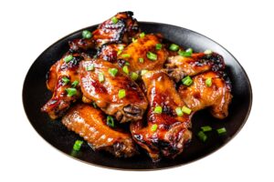 Plate of glazed bourbon chicken wings garnished with chopped green onions