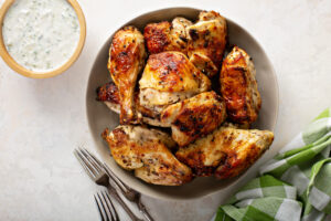 Plate of Paleo Greek chicken pieces roasted golden brown with herbs and lemon