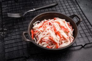 Bowl of shredded crab meat for Crohn’s-friendly faux sushi on a cooling rack