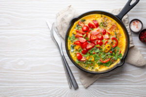 Paleo spinach and tomato frittata in a cast iron skillet.